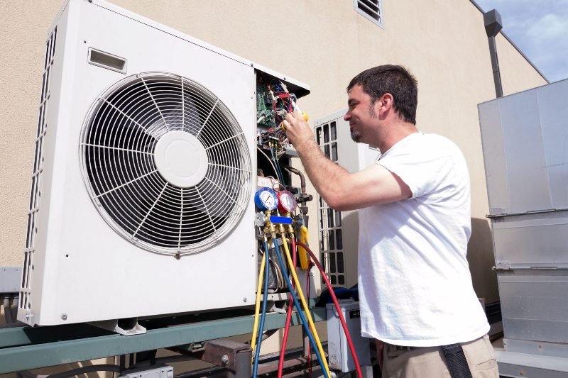 Technician maintaining HVAC system